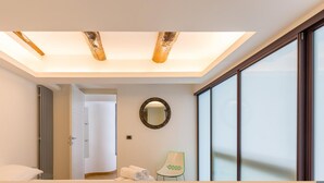 A modern bathroom with a skylight, a large mirror, and a view of the outside.