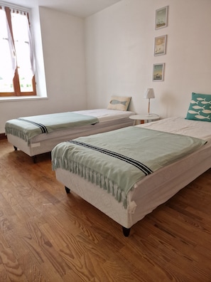 A room with two single beds, a small bedside table with a lamp, and a window with curtains. - Countryside close to beaches and tourist attractions (Saujon)
