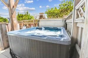 Ein Whirlpool in einer Außenanlage mit Holzterrasse und Holzzaun.