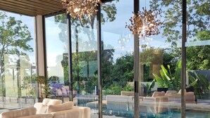 A modern dining area with a large wooden table, leather chairs, and a hanging light fixture. - Villa Obsidian (Koh Samui)