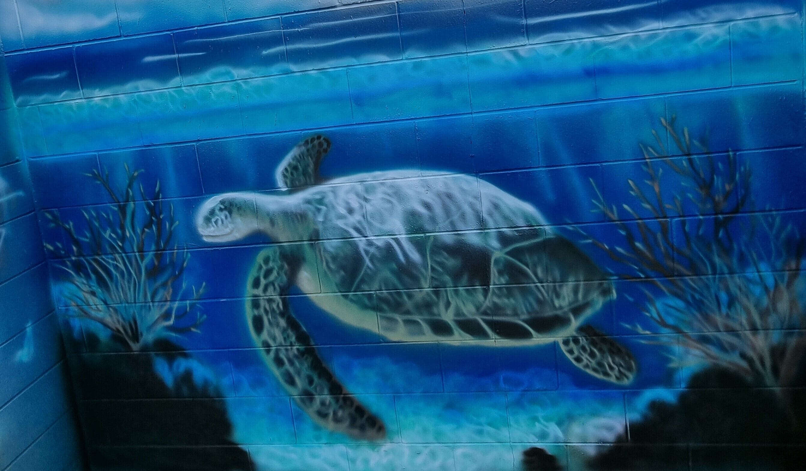 A mural of a sea turtle swimming underwater.
