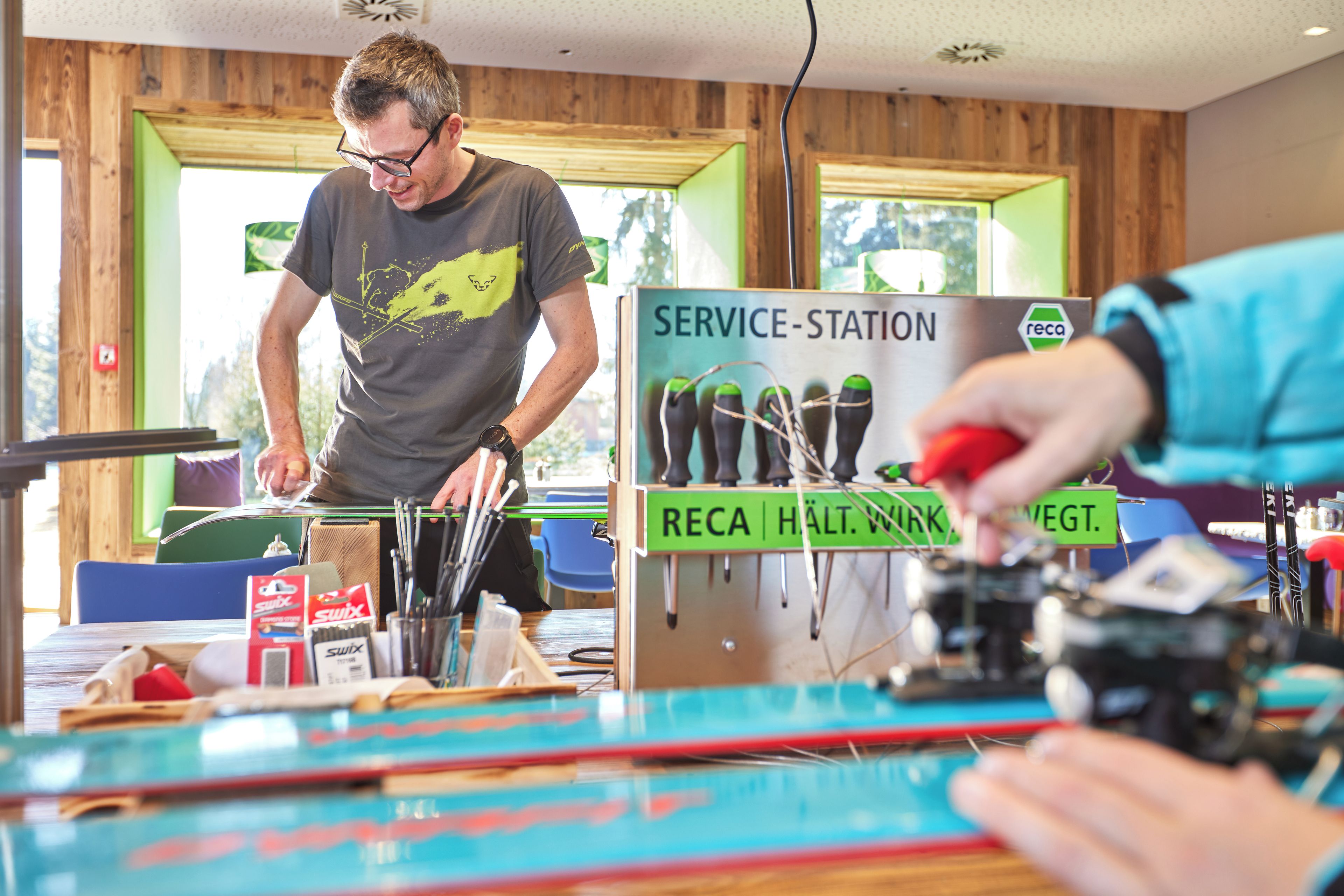 Een man werkt aan een tankstation, met gereedschap en apparatuur.