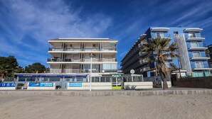 Un hotel de varios pisos con balcones, un restaurante y un área de descanso.