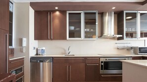 A modern kitchen with stainless steel appliances, wooden cabinets, and a built-in microwave. - Modern Apartment in Salou with Sea View (Salou)