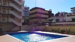 A swimming pool surrounded by multi-story buildings with balconies. - Cozy 2BR Apartment with Pool, Wi-Fi, and Private Terrace in Salou's Lively Tourist Area (Salou)