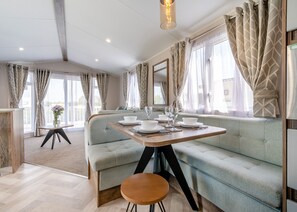 A modern room with a dining table set for four, a sofa, and a small side table.