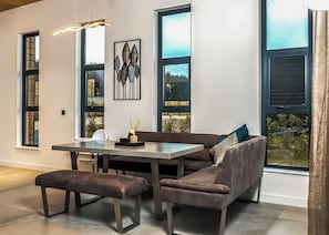 A modern dining area with a bench, table, and sofa.