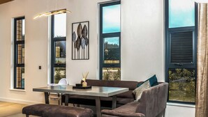 Un espace de salle à manger moderne comprenant un banc, une table et un canapé.
