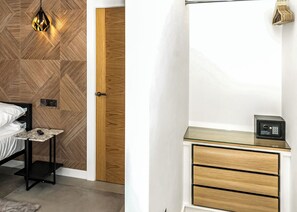 Une chambre à coucher avec un lit, une table de chevet, une lampe et une armoire en bois.