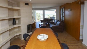 A spacious room with a wooden dining table, a sofa, and a fireplace. - Comfortable Apartment in Salou Beachfront with Air Conditioning (Salou)