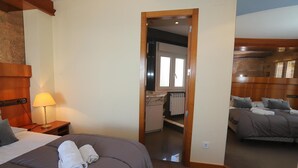 A hotel room with a large bed, a bedside lamp, a mirror, and a view of a bathroom. - Comfortable Apartment in Salou Beachfront with Air Conditioning (Salou)