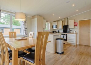A modern kitchen with wooden cabinets, a built-in microwave, and a stainless steel range hood.