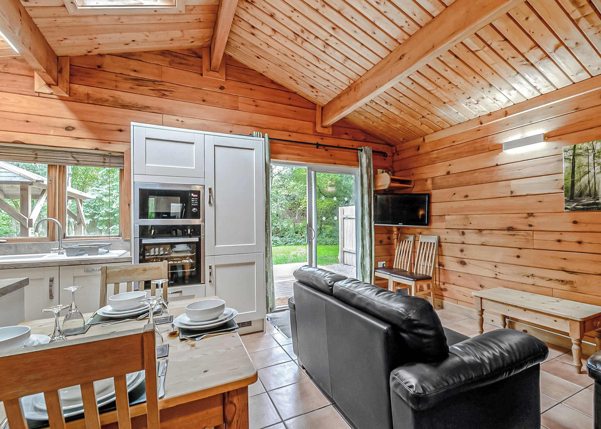 L’intérieur d’une cabane en bois comprend une cuisine, un coin repas et un espace salon.
