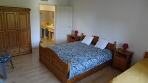 Un dormitorio con cama de madera, una mesita de noche, una silla y un armario.