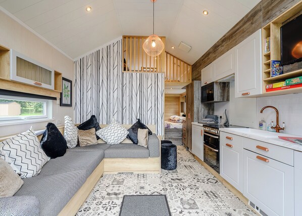 A modern kitchen with white cabinets, a built-in oven, and a microwave.