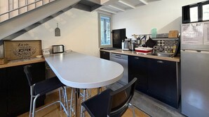 Una cocina moderna con comedor, una escalera y un ventanal.