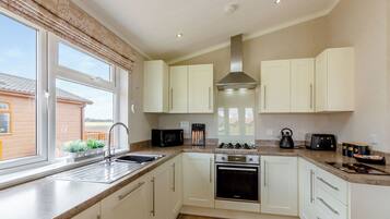 A modern kitchen with white cabinets, a built-in oven, a microwave, and a gas stove.