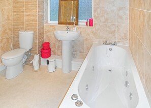 A bathroom with a toilet, sink, and bathtub.
