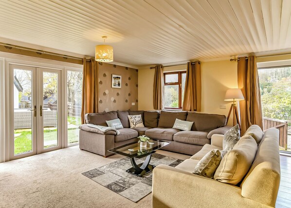 A living room with a sectional sofa, a coffee table, and a lamp.