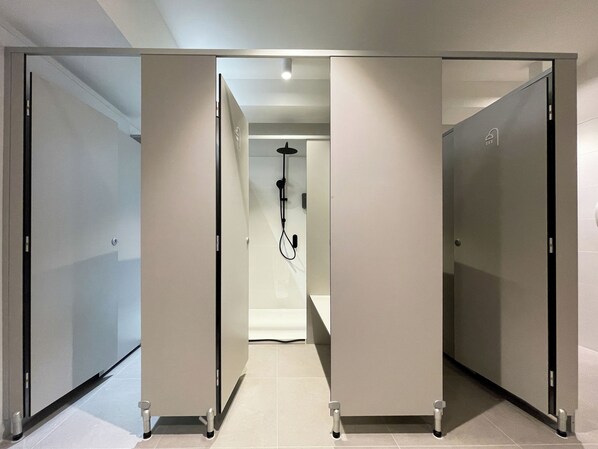 A modern hotel corridor with glass doors leading to individual rooms. - Airone Capsule Hotel (Hobart)