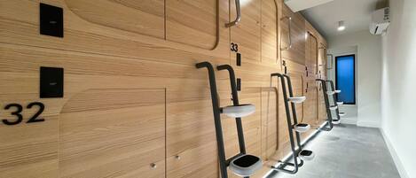 A row of wooden lockers with numbers 31, 32, 33, and 35, and metal step stools with built-in sinks.