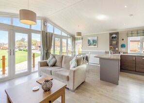 Ein geräumiger Wohnbereich mit einer Couch, einem Holztisch und einer Kücheninsel.