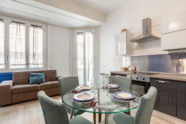 A modern apartment with a dining area, kitchen, and living space.