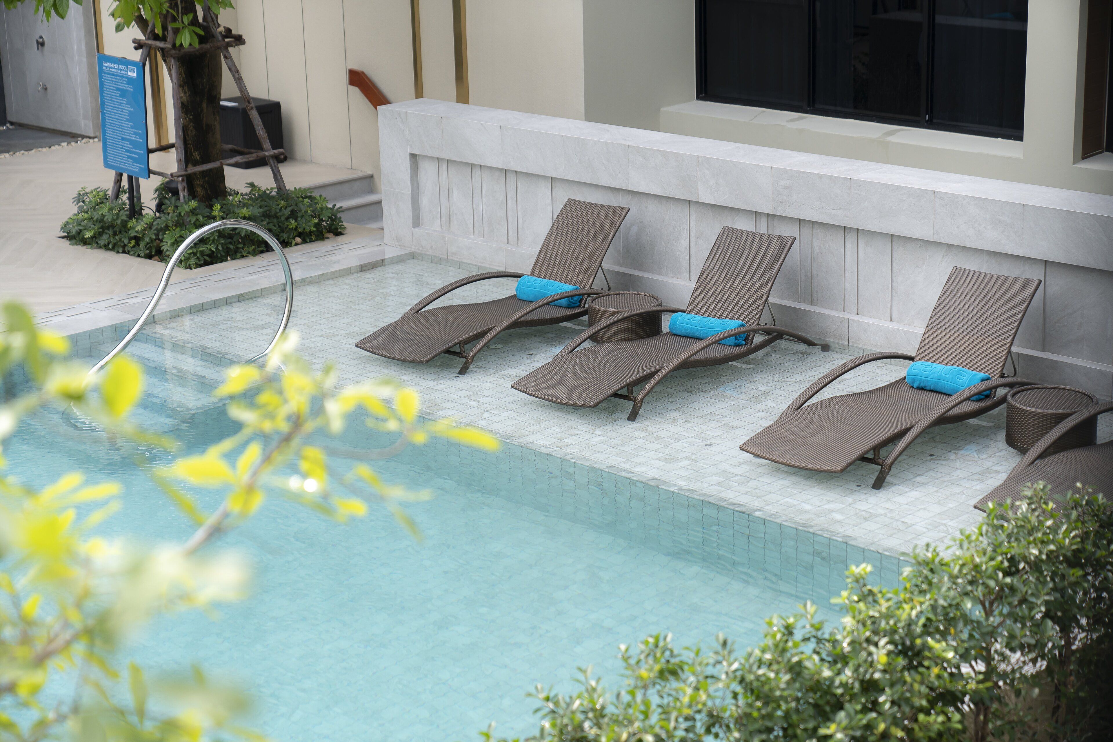 A poolside area with lounge chairs and a water feature.