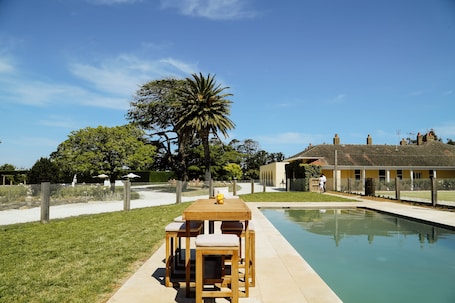 Una piscina al aire libre, sombrillas, sillones reclinables de piscina. Mount William Station