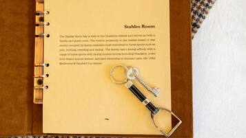 Une page intitulée « Salle des écuries » dans un livre à spirale, avec un porte-clés fixé à la page.