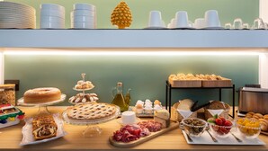 A buffet with various food items including cakes, pastries, and meats. - Vossia Luxury Rooms & Sicilian Living (Palermo)