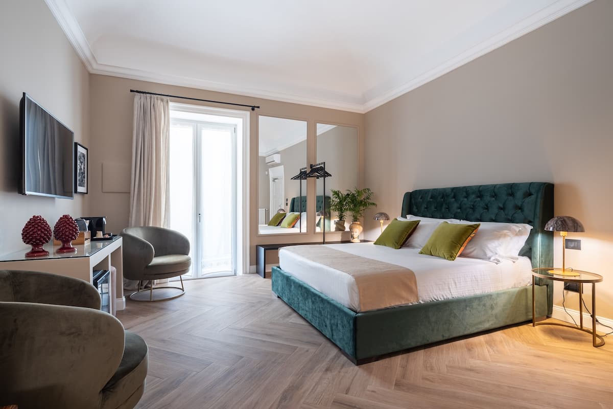Una habitación de hotel moderna con una cama grande, un escritorio, una silla y un televisor.