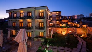 Un hôtel à plusieurs étages doté de balcons, de sièges en plein air et d’une cour bien éclairée.