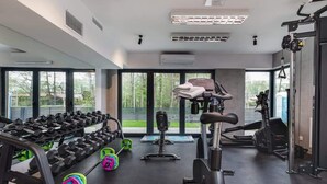 A modern gym with various equipment like dumbbells, a bench press, and a treadmill. - Intimate Apartment | SPA & Gym | 550 m to the beach (Miedzywodzie)