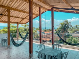 Un espacio de estar al aire libre techado con vistas a un barrio residencial y montañas.