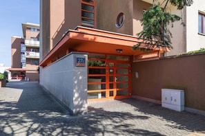 A building entrance with a red door, a mailbox, and a number '27' sign.