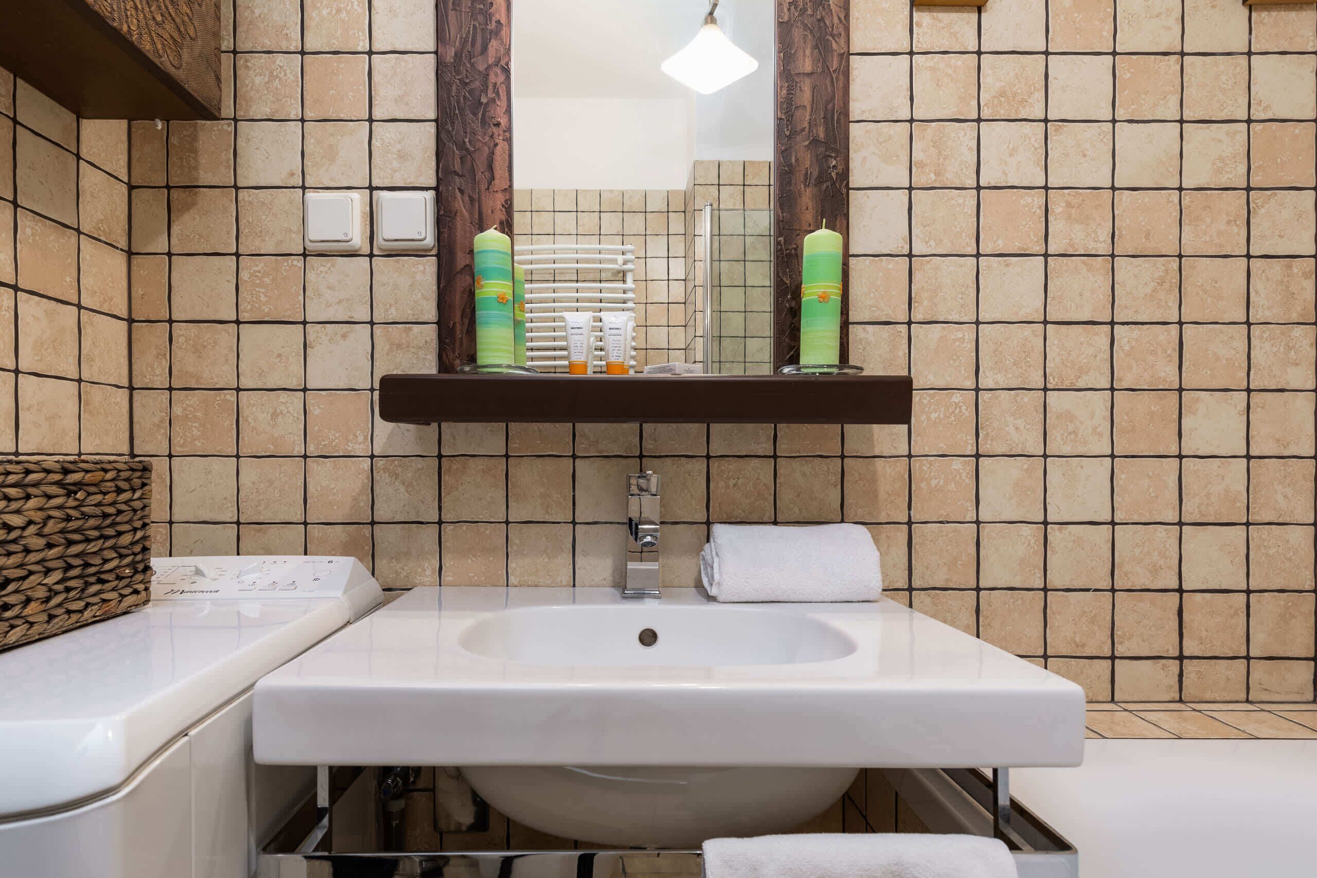 Une salle de bain avec un lavabo blanc, un miroir et un porte-serviettes.