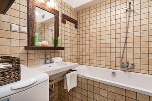 Bañera, secador de pelo, toallas, shampoo