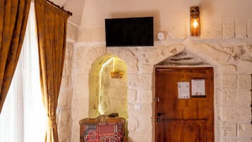 A stone wall with a flat-screen TV mounted above a wooden door.