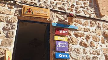 Een gebouw van steen met een bord waarop 'MASSIUS Boutique Hotel, Cafe, Food & Art' staat.