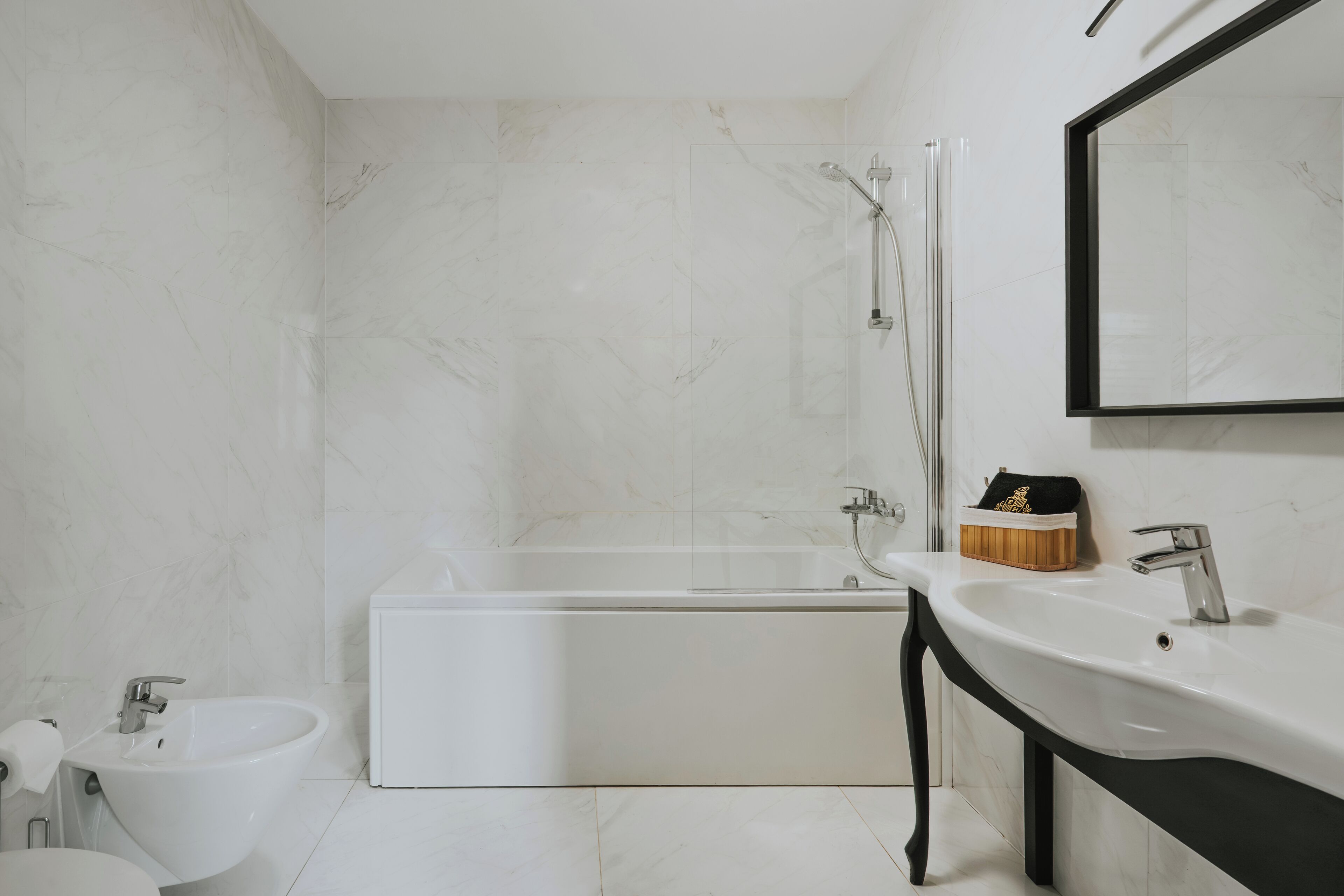 Un baño moderno con bañera, lavamanos y espejo.