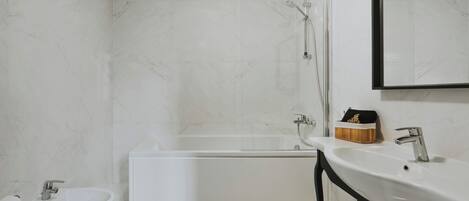 Un baño moderno con bañera, lavamanos y espejo.