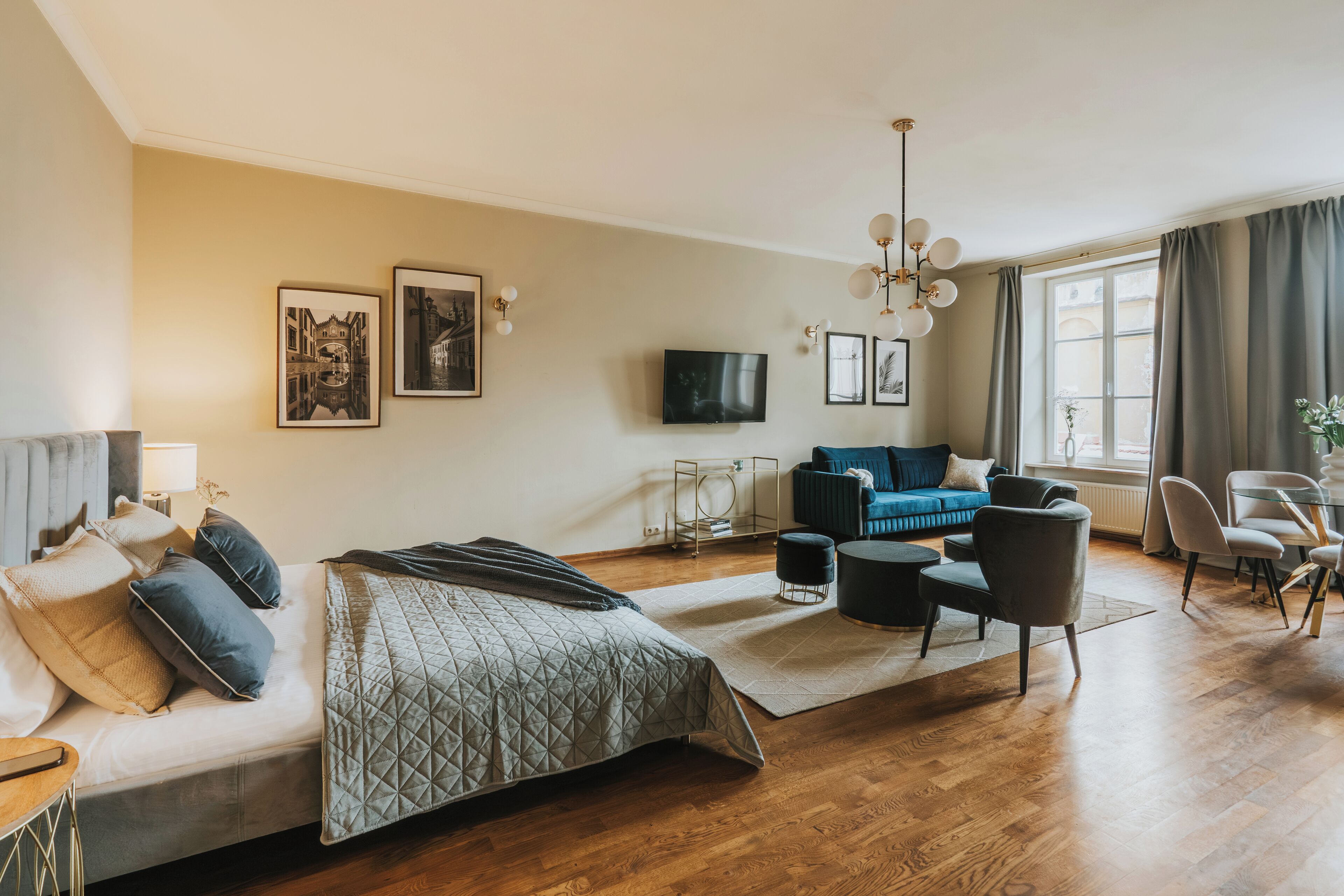 Een moderne hotelkamer met een bed, een bank, een televisie en een zithoek.