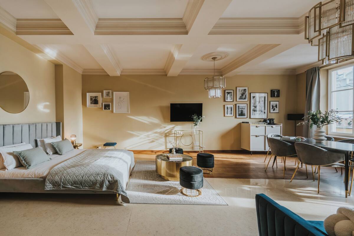 Een moderne slaapkamer met een bed, nachtkastjes, een bureau en een zithoek.