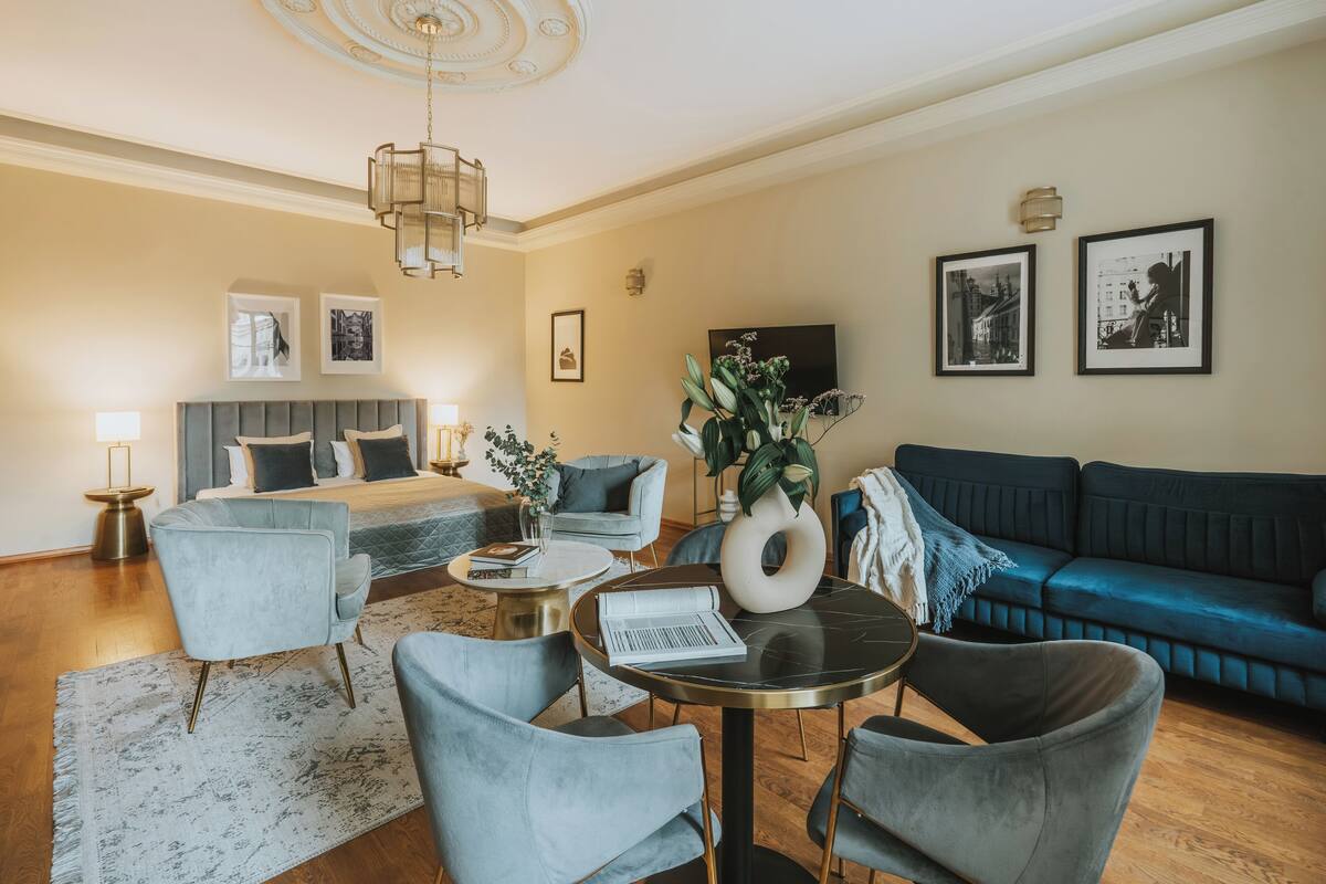 Een moderne woonkamer met een bank, fauteuils, een salontafel en een televisie.