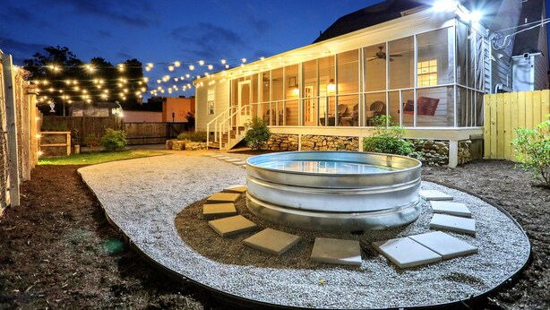 A backyard with a hot tub, stone steps, and string lights. - Luxury Memphis Musical Estate! Pool, Games! (Memphis)