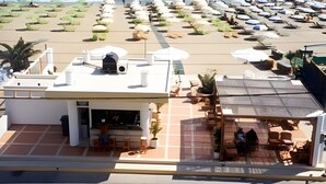 A beachside hotel with a patio area, a pool, and a view of the ocean. - Smaragdine Beach (Hersonissos)