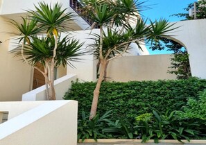 A modern building with a white facade, a staircase, and a well-maintained hedge. - Smaragdine Beach (Hersonissos)