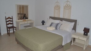 Une chambre à coucher comprenant un lit, une chaise, un bureau, une lampe et des éléments de décoration murale.