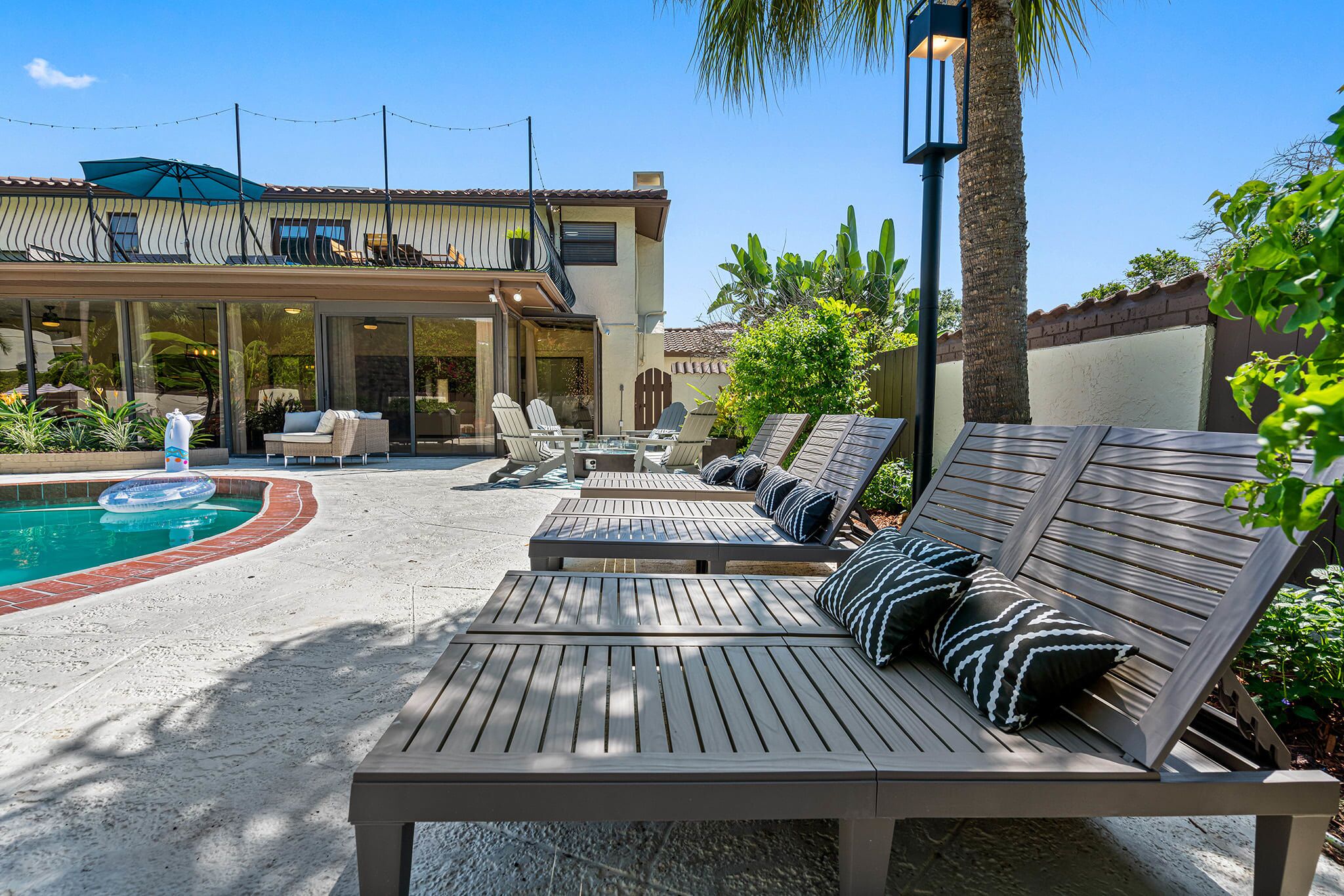 A poolside area with lounge chairs and a pool.